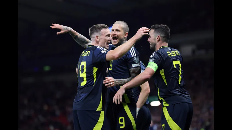 Cầu thủ Scotland đi bóng qua cầu thủ Belarus trong trận đấu bóng đá